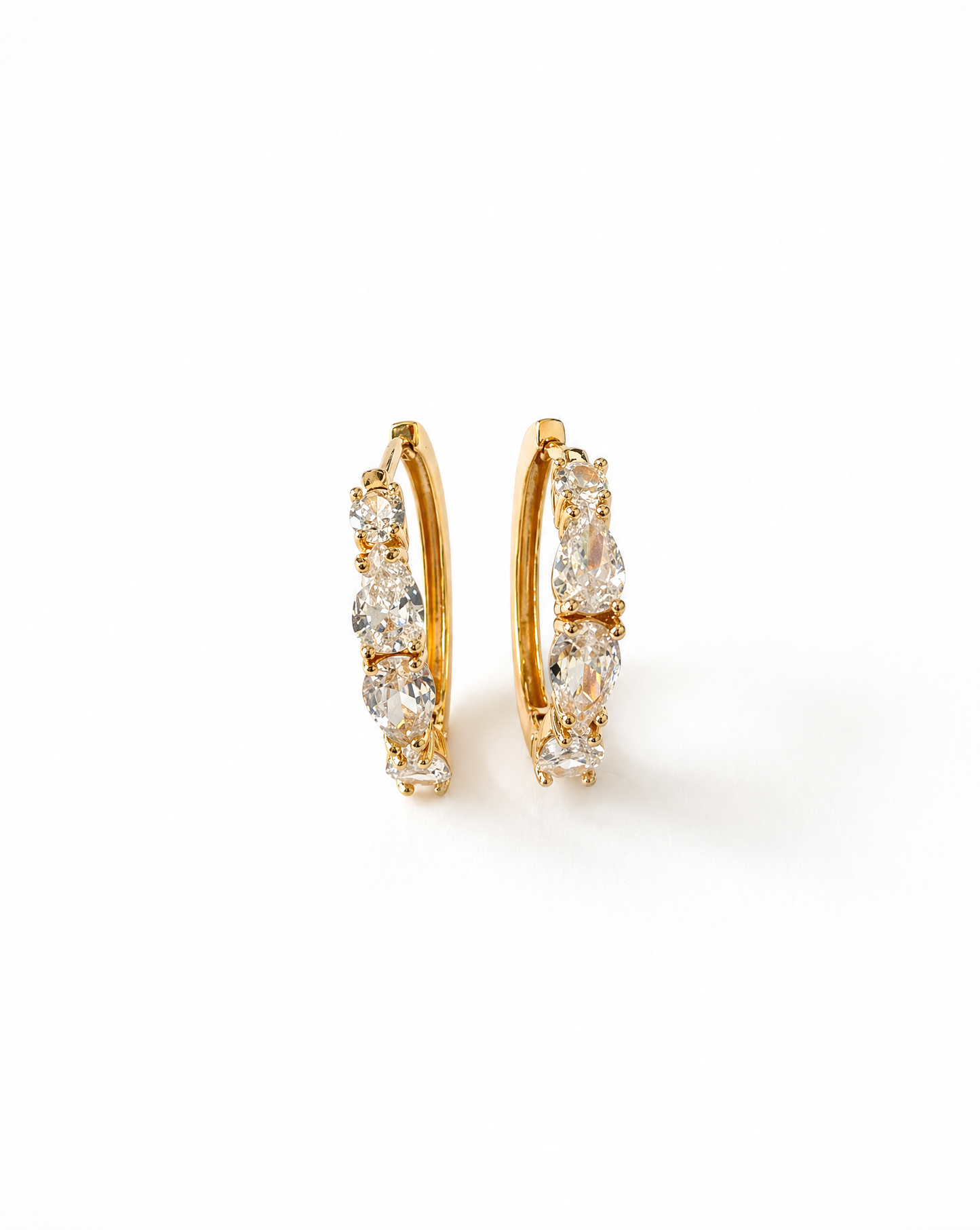 Gold hoop earrings with clear gemstones on a white background